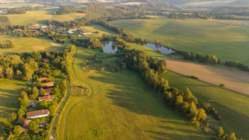 Letecký pohľad na krajinu s lúkami, rybníkmi a dedinou